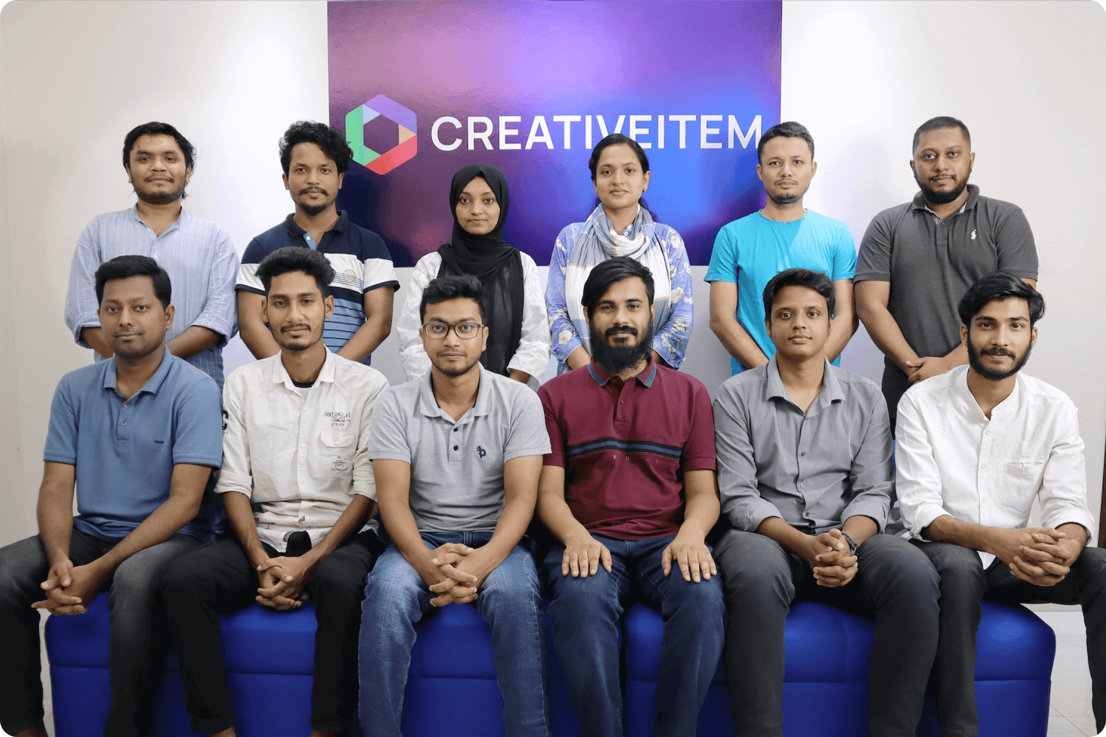 Group photo of the Creativeitem team, against the Creativeitem logo