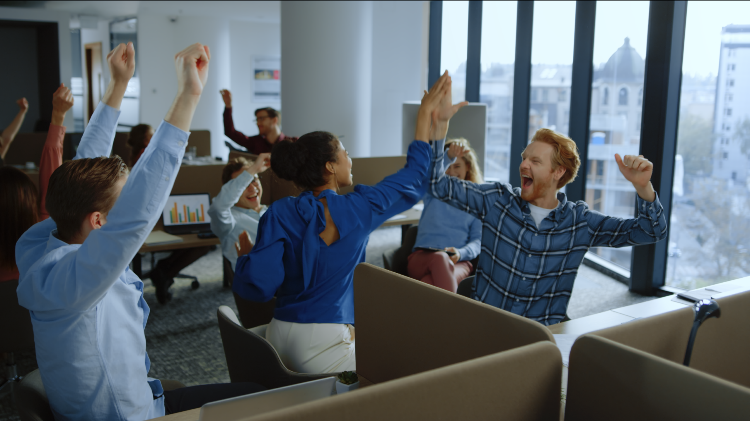 Screenshot of a stock footage item. The screenshot shows an office scene with a large group of people excitedly cheering and celebrating.