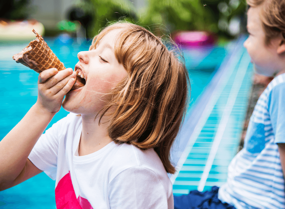 A photo from the 'summer vibes' collection, curated by our photo & video review teams. This photo depicts a young child eating an ice cream.