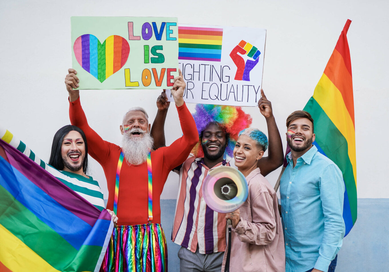 Happy multiracial people laughing with banner at gay pride parade - Homosexual love by SabrinaBracher. Asset appears to be at a Pride march. 

