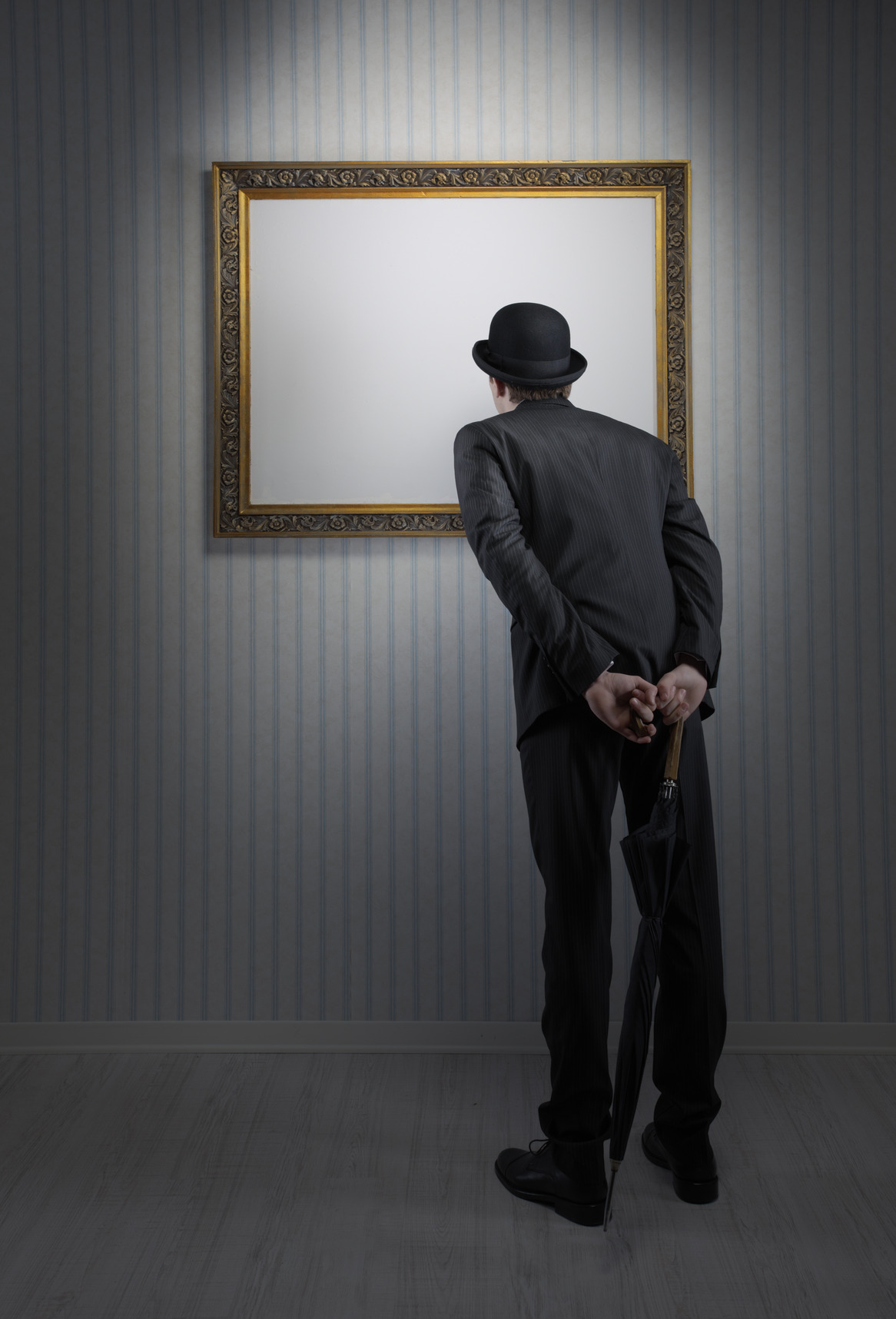 Retro elegant man standing and observing a empty frame in a museum