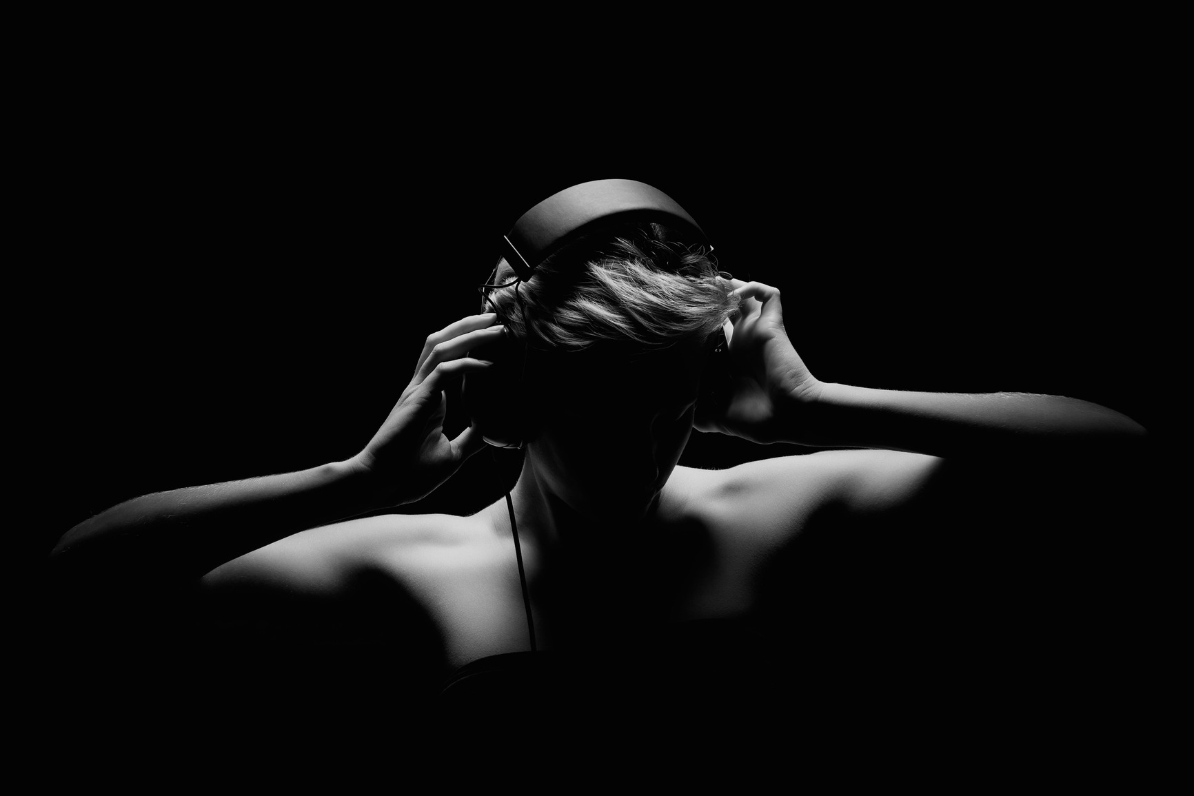 blonde woman listening to music in black and white tense light
